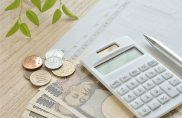 電卓とお金の画像